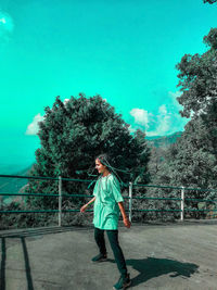 Full length of man standing by railing against sky