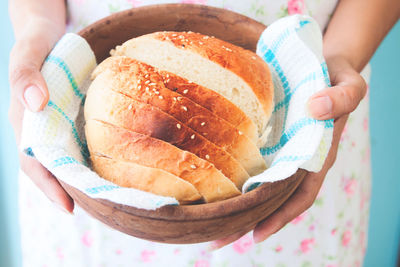 Midsection of person holding bowl with bread