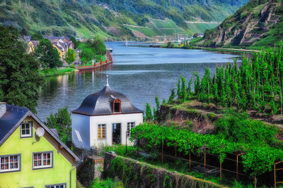 Houses by lake and buildings against mountain