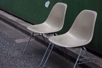 Empty chairs on footpath