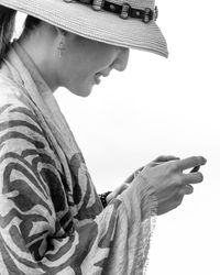 Side view of woman texting against white background
