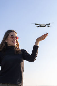 Small drone landing on young woman's palm