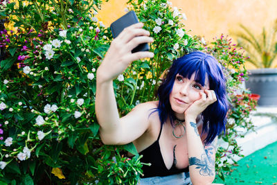 Photo of adorable young woman making selfie outdoors backyard