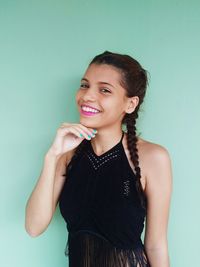 Portrait of young woman standing against white background