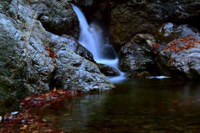 Scenic view of waterfall amidst rocks hinohara shutter speed 