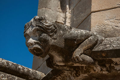 Low angle view of statue against old wall