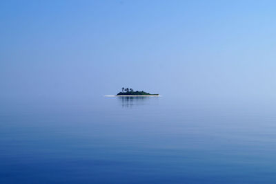 Small island against blue sky