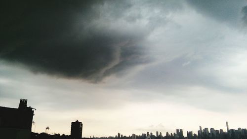 Low angle view of buildings against cloudy sky