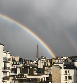 Rainbow over cityscape against sky