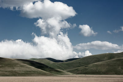 Scenic view of landscape with green hills against sky