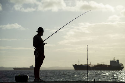 Silhouette of fishermen with their poles at sunset.