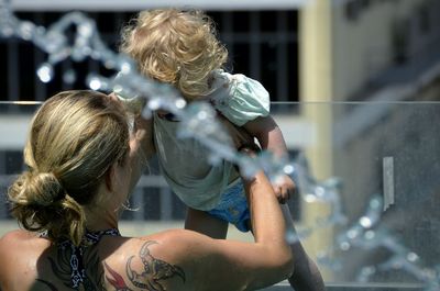 Rear view of mother carrying daughter