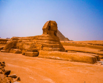 Rock formations on landscape against clear blue sky