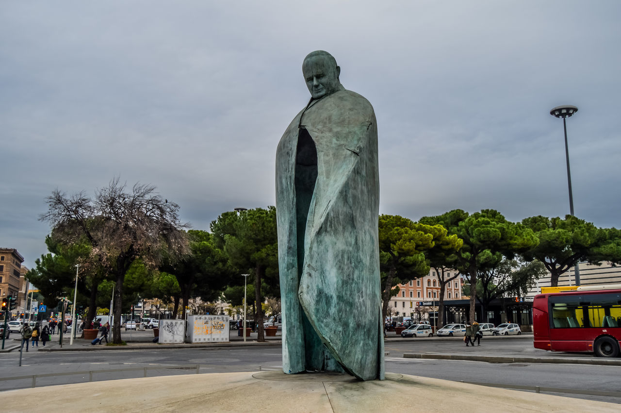 STATUE BY STREET AGAINST SKY