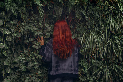 Rear view of woman standing by plants