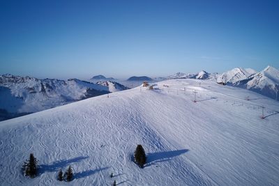 Scenic view of snowcapped mountains against blue sky