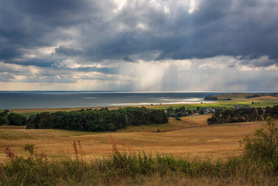 Scenic view of field against cloudy sky