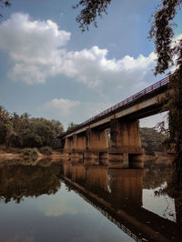 Arch bridge over lake against sky