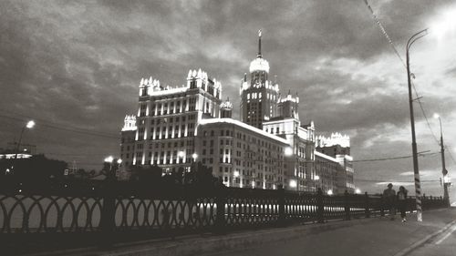 Buildings in city against cloudy sky