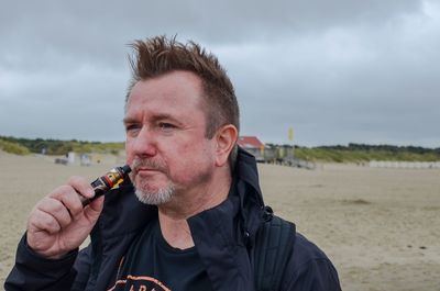 Portrait of man holding cigarette