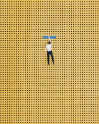 Rear view of woman standing on yellow umbrella