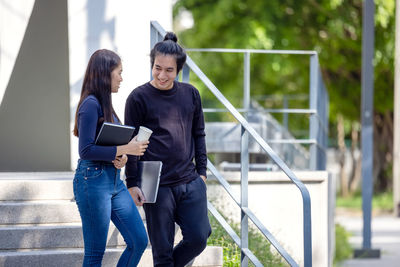 Young couple standing on railing