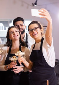 Portrait of smiling friends using smart phone