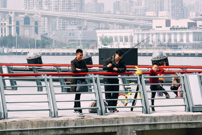 Men in boat on river in city