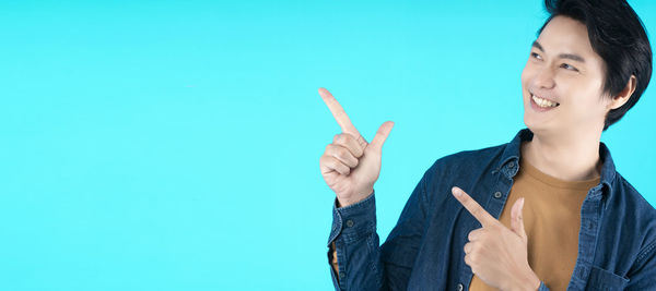 Portrait of smiling man holding ice cream against blue background