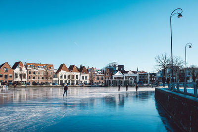 View of frozen river against buildings