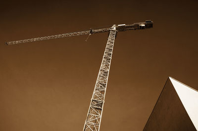 Low angle view of crane against building