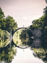 Arch bridge over river against sky