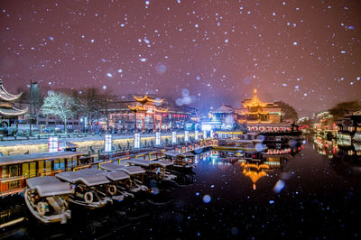 Panoramic shot of illuminated cityscape against sky at night