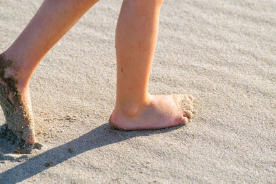 Low section of person legs on sand