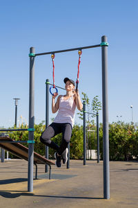 Woman in sportclothes working out on the sports ground in sunny summer day