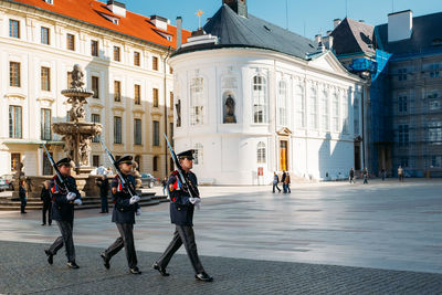 People walking on road amidst buildings in city