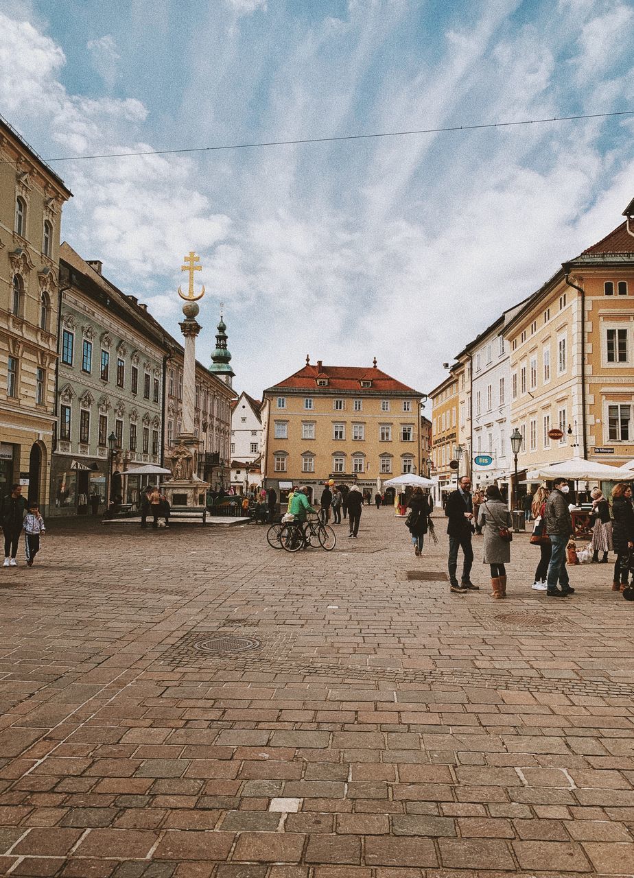 PEOPLE ON STREET BY BUILDINGS IN CITY