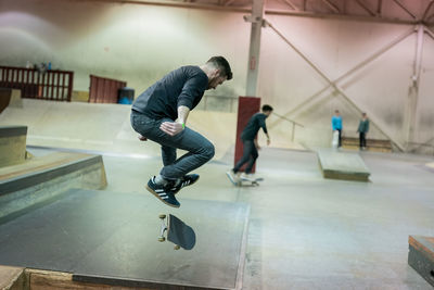 Full length of man skateboarding in corridor