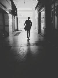 Rear view of silhouette man walking in building