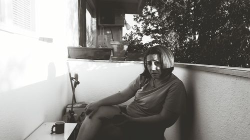 Portrait of young man sitting on wall