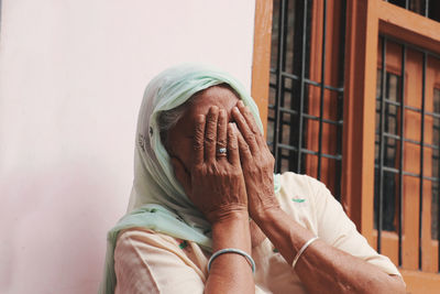 Close-up of senior woman covering face at home