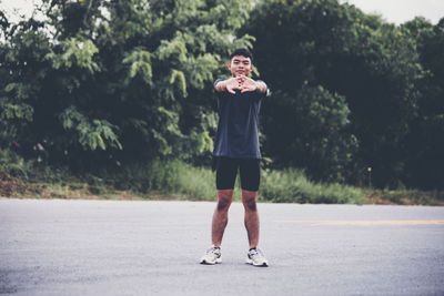 Full length portrait of man standing on road