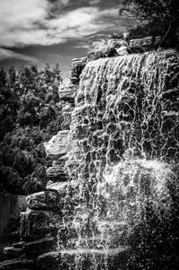 Scenic view of waterfall against sky