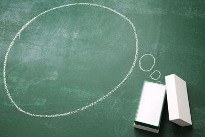 Containers with speech bubble on blackboard