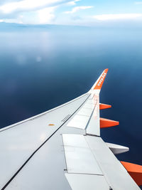 Airplane flying over water against sky