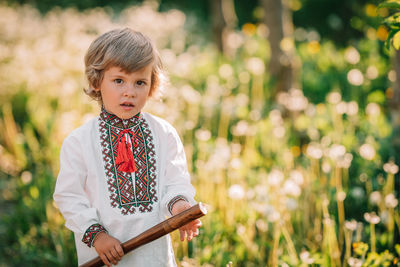 Portrait of boy standing against plants