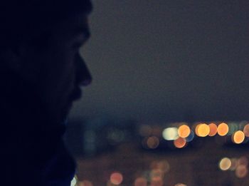 Close-up of illuminated lights against sky at night