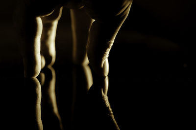 Low section of person against black background