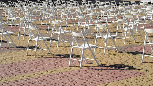 Folding white chairs are placed on the square in anticipation of concert, performance.