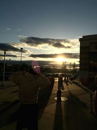 Road passing through city at sunset